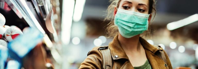 woman grocery shopping with a mask on